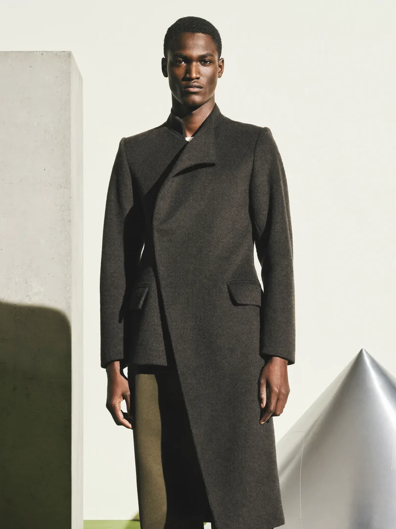 Étude illustrée d'un manteau asymétrique en laine charbon.